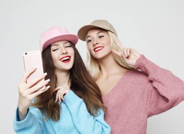 Hippi kıyafetli iki genç kız arkadaş selfie çekiyorlar.