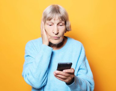 Yaşlı nine onun akıllı telefon görünüyor ve şaşırır