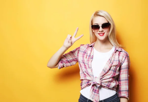 Portret van een prachtige vrouw die glimlachend naar de camera kijkt en met haar vingers vrede toont — Stockfoto