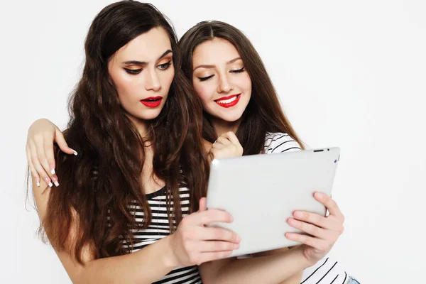 Duas meninas amigas tomando selfie com tablet digital sobre fundo branco — Fotografia de Stock