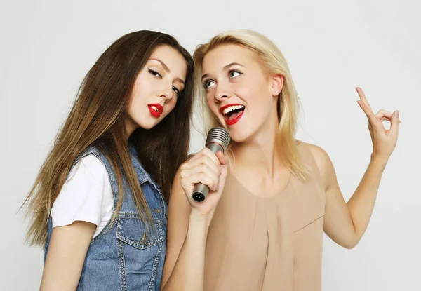 Skönhet flickor med en mikrofon sjunga och ha kul tillsammans — Stockfoto
