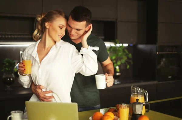 Couple at home having coffee in kitchen and working on laptop computer, lifestyle concept — Stock Photo, Image