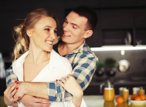 Lovely young couple standing and hugging on a kitchen at home — Stock Photo, Image