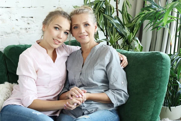 Hermosa mamá mayor y su hija adulta están abrazando, mirando a la cámara y sonriendo. —  Fotos de Stock