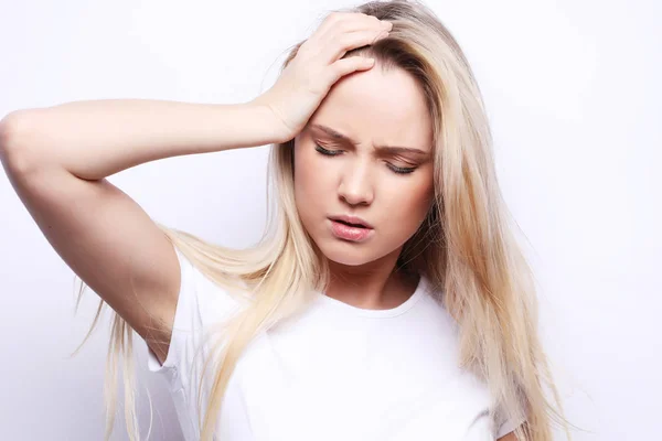 Mladá žena má bolesti hlavy, přes bílé pozadí — Stock fotografie