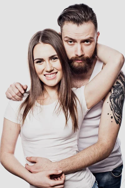 Casal feliz abraçando e olhando câmera no fundo branco — Fotografia de Stock