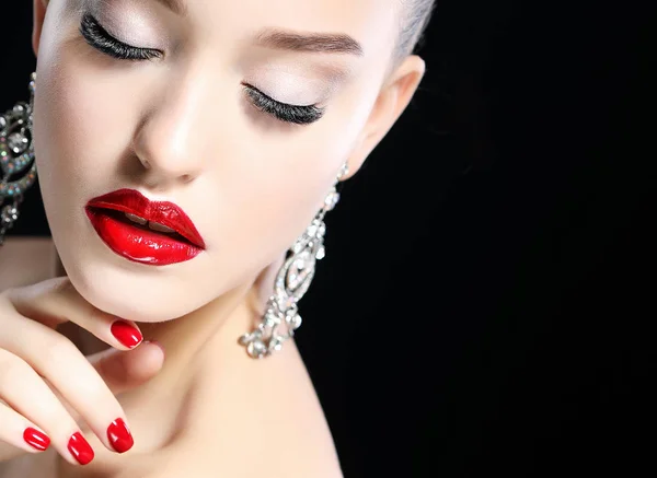 Potret wanita cantik muda dengan malam make up menyentuh wajahnya di atas latar belakang hitam. Bibir merah dan kuku . — Stok Foto