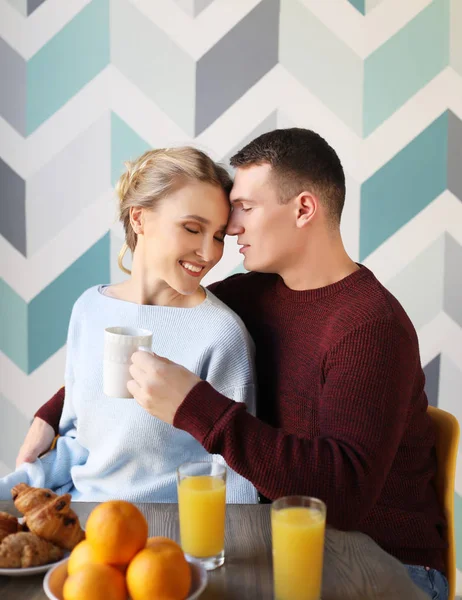 Young couple eating breakfast early in the morning in the kitchen and having a good time. — Stock Photo, Image