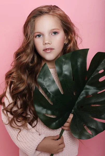 Little girl wearing pink outfit and holding flower — Stock Photo, Image