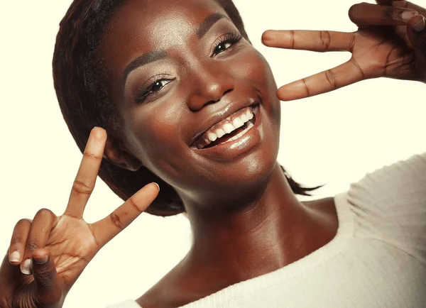 Mujer afroamericana sonriendo mirando a la cámara mostrando los dedos haciendo señal de victoria —  Fotos de Stock