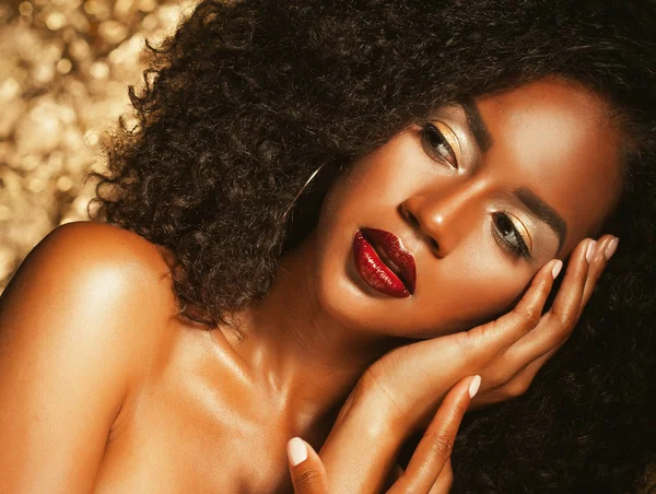Jeune femme afro-américaine élégante avec des cheveux afro. Maquillage glamour. Arrière plan doré . — Photo