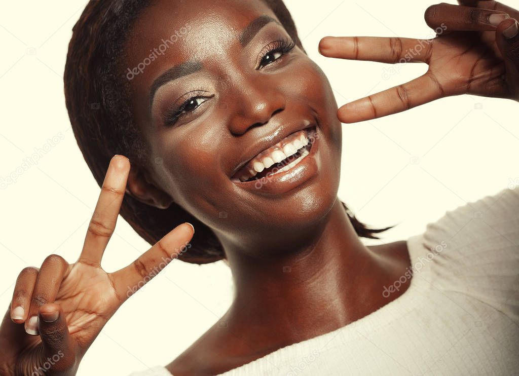 African american woman  smiling looking to the camera showing fingers doing victory sign