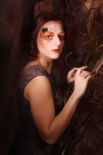 Mujer con maquillaje brillante con ramas secas — Foto de Stock
