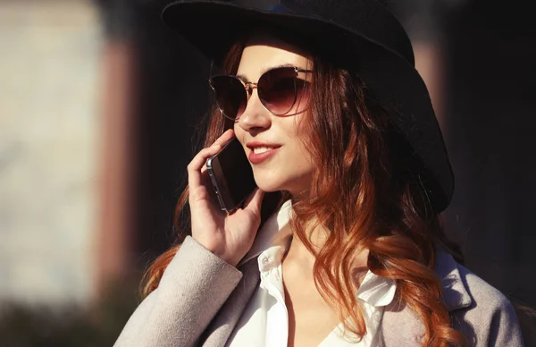 Lächelnde junge Frau telefoniert und spricht auf dem Smartphone — Stockfoto