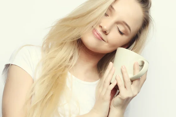 Молода жінка з білою чашкою чай або кава, на білому тлі — стокове фото