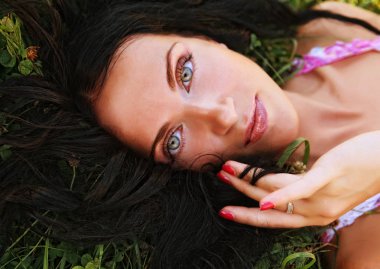 çimenlerin üzerinde genç gülümseyen kadın 