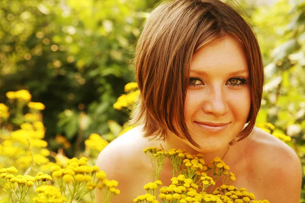 Genç bir kadın ve kır çiçekleri. — Stok fotoğraf