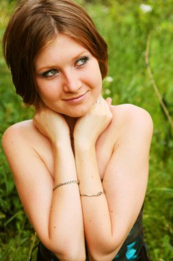 Genç kadın çimenlerde dinleniyor. 