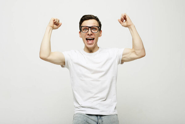 Happy young handsome man gesturing and keeping mouth open