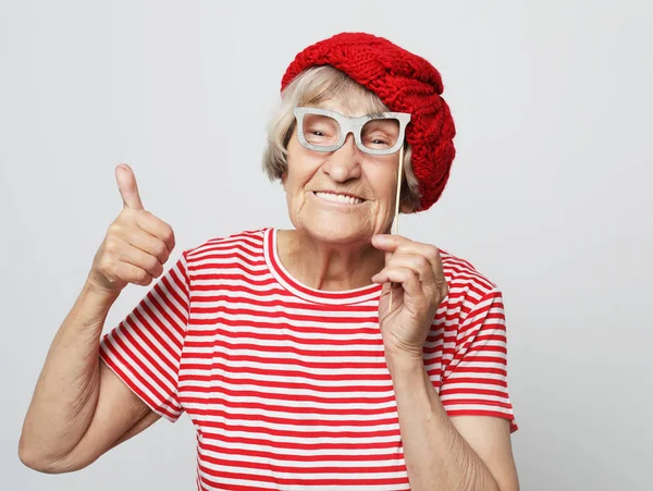 Styl życia, emocje i koncepcja ludzi: zabawna babcia w sztucznych okularach, śmiech i gotowa do zabawy — Zdjęcie stockowe
