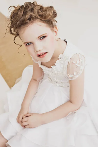 Little girl with blond hair wearing white dress. — Stock Photo, Image