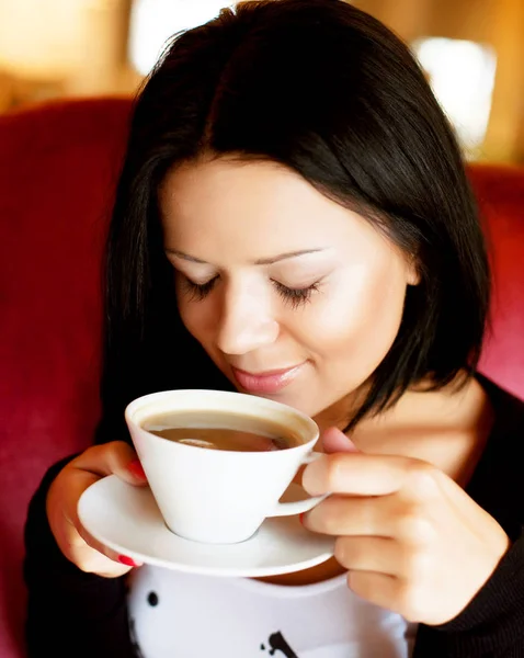 Jovem mulher sentada em um café bebendo café — Fotografia de Stock