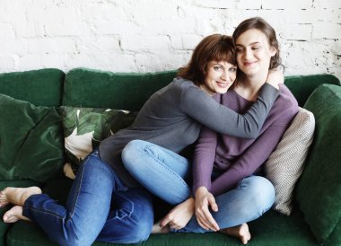   Mutlu kıdemli anne yetişkin kızı kucaklıyor birlikte gülüyor, yaşlı bayan genç bayanı kucaklıyor.