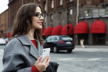 Arama ve smartphone sonbahar City'deki konuşurken genç gülümseyen