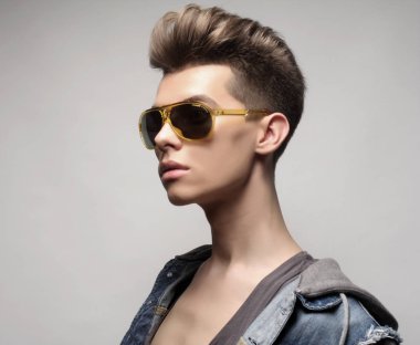 Beyaz arka planda güneş gözlüklü güzel genç adam. Moda konsepti.