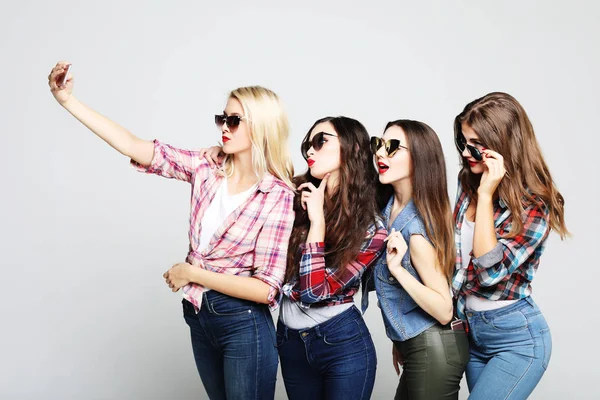 Cuatro chicas adolescentes felices con teléfono inteligente tomando selfie — Foto de Stock