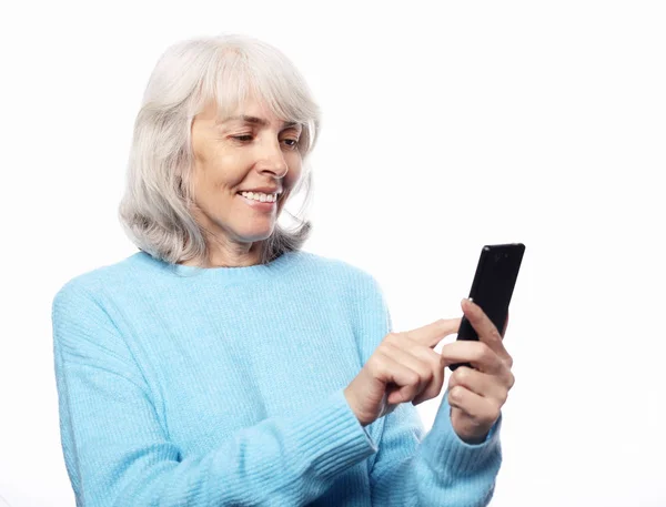 Životní styl, tehnologie a lidé koncept: starší žena s smartphone textové izolované na bílém pozadí — Stock fotografie