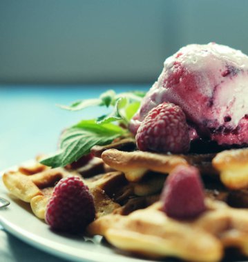 Waffle ahududu Ice cream ve nane ile dekore edilmiş mavi ahşap arka plan üzerinde taze frambuaz