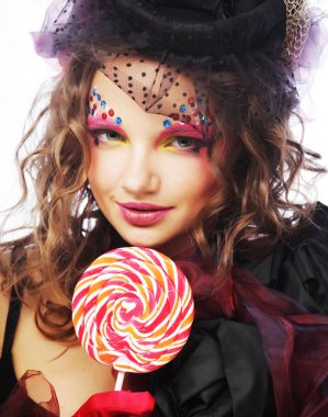 Yaratıcı makyajlı kız lolipop tutuyor. 