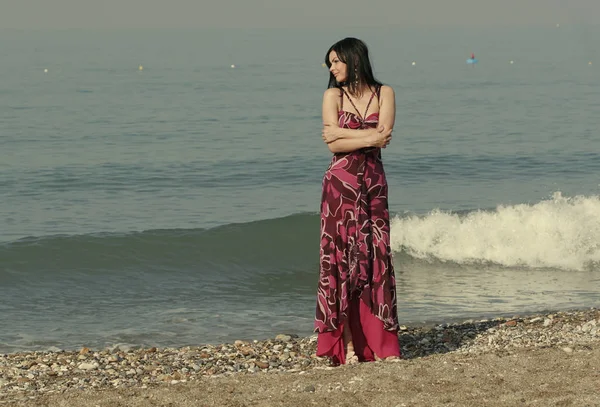 Жінка в рожевій сукні на березі моря — стокове фото