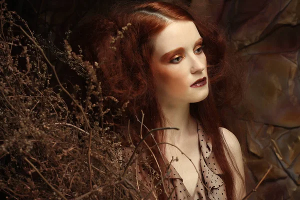 Kvinna med ljusa make up med torra grenar — Stockfoto