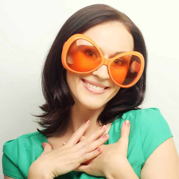 Mujer feliz joven con grandes gafas de sol naranjas —  Fotos de Stock