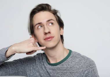  Genç çekici adam telefon işareti yapıyor.