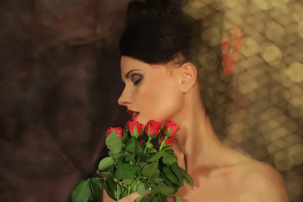 Krásná žena s rudými růžemi. — Stock fotografie