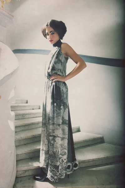 Elegante donna in abito lungo su scale vintage — Foto Stock