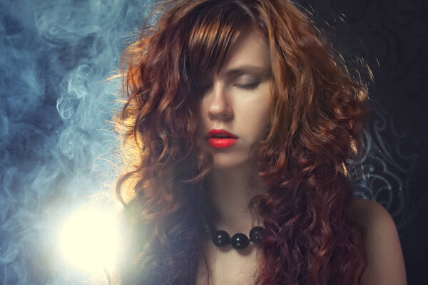 Fashion shoot of young and sexy woman in smoke