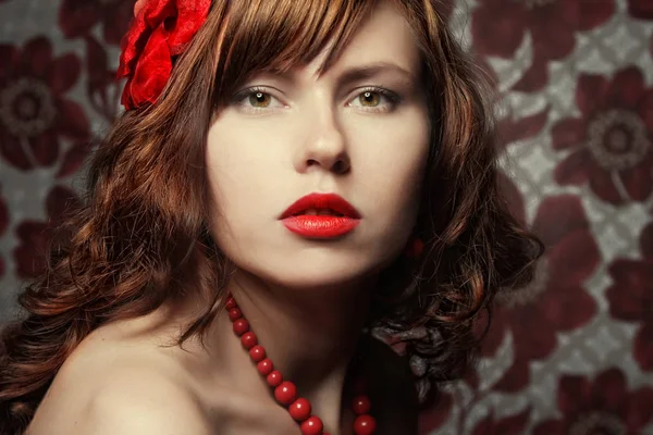 Krásná dívka s červenými květina ve vlasech — Stock fotografie