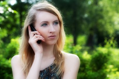 açık havada cep telefonu kullanan kadın