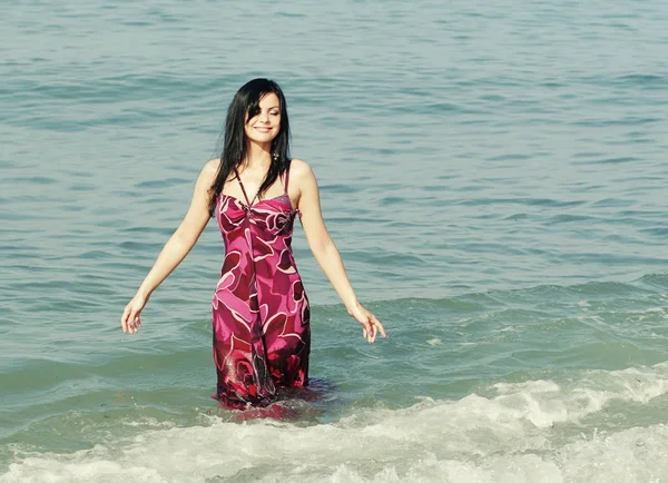 Усміхнена жінка стоїть у морських хвилях — стокове фото