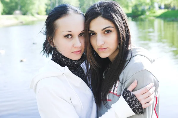 Duas mulheres jovens junto ao lago se divertindo — Fotografia de Stock