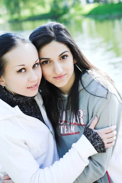 Dvě mladé ženy u jezera baví — Stock fotografie