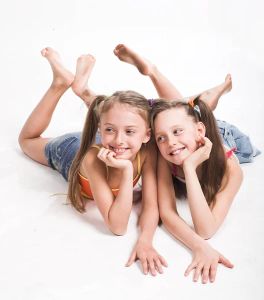 Duas meninas bonitas que colocam no branco — Fotografia de Stock