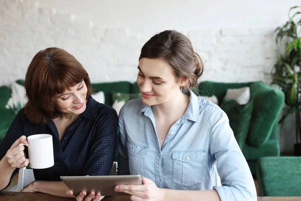 Madre e figlia adulta utilizzando tablet computer a casa — Foto Stock