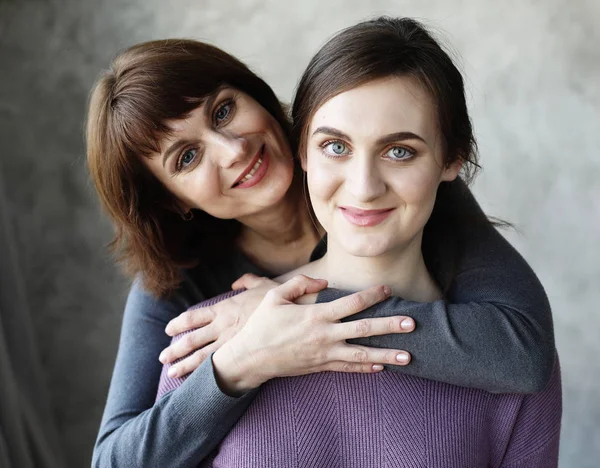 Feliz madre mayor abrazando hija adulta riendo juntos, señora mayor abrazando a mujer joven — Foto de Stock