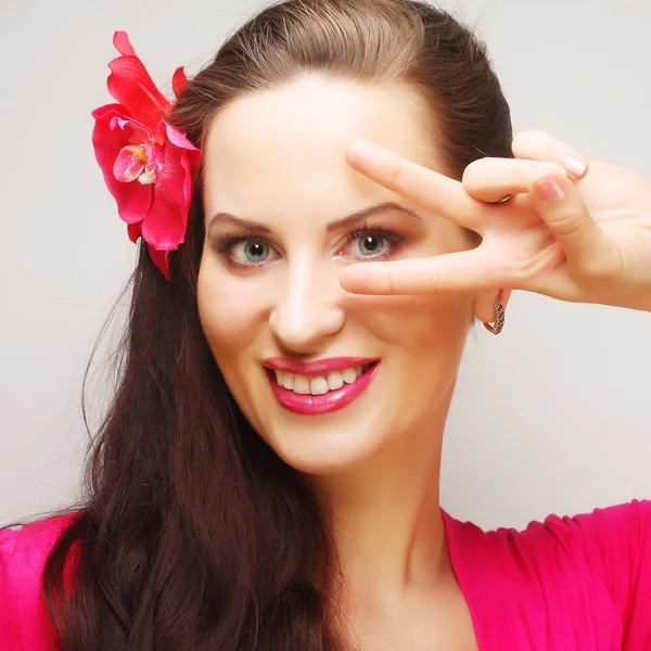 Peeking through fingers, young woman — Stock Photo, Image