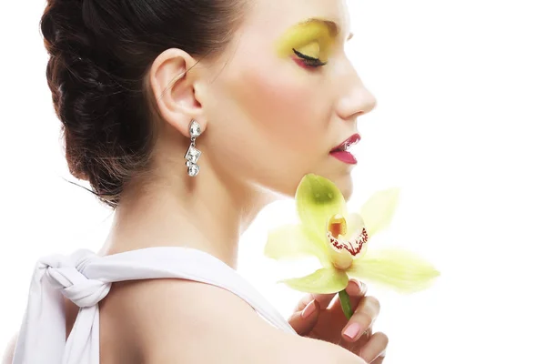 Молодая женщина с ярким макияжем держа орхидею — стоковое фото